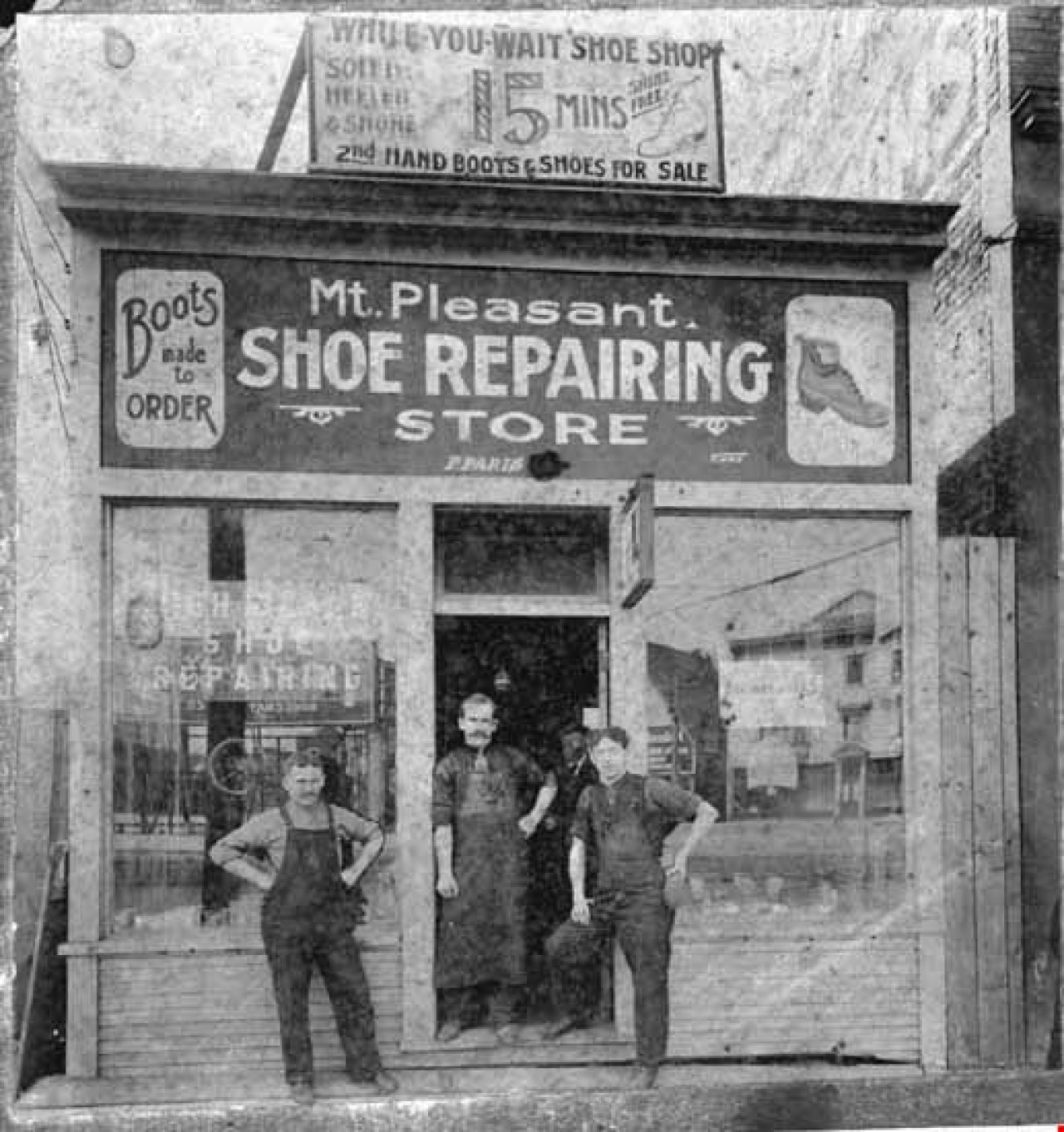 Men standing outside Mt. Pleasant Shoe Repairing Store. Credit: Vancouver Public Library 84911