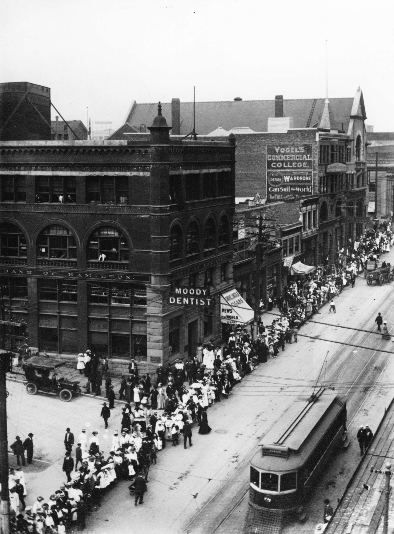 View of 300 block West Hastings Street at Hamilton Street with queue of people on the sidewalk lining up to purchase Shaughnessy lots from the C.P.R, 1909. City of Vancouver Archives, CVA 677-653.